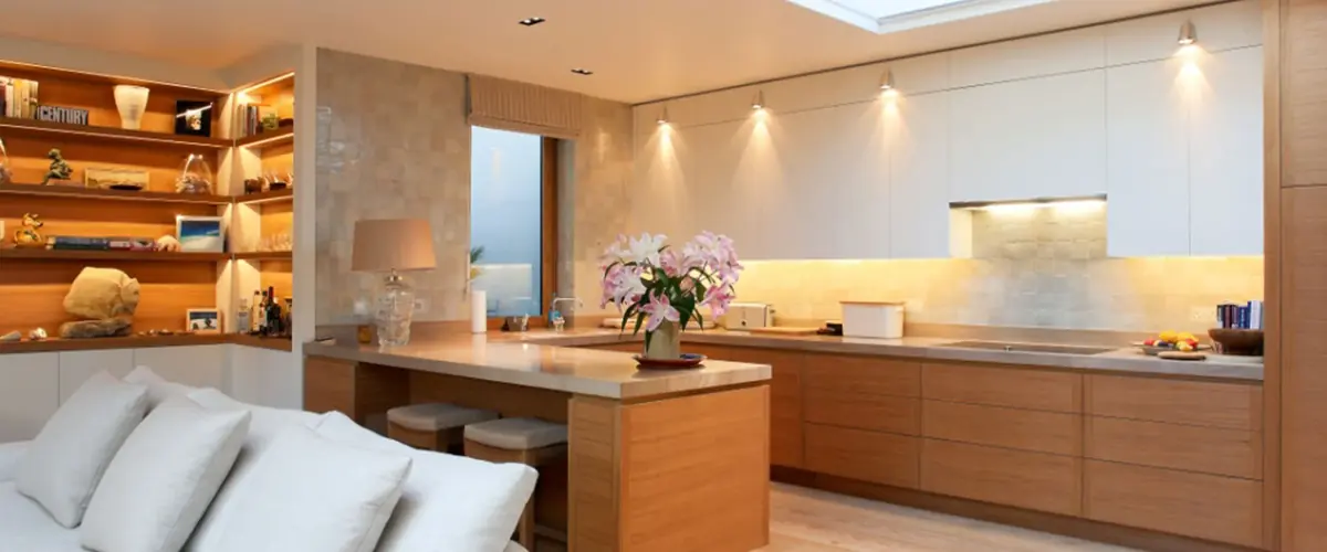 Open plan oak kitchen and living room with lit shelving in a Kensington mews, bespoke residential joinery